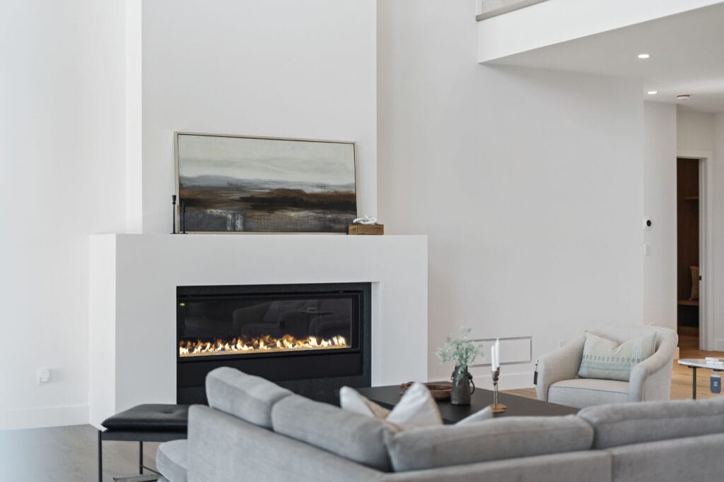 Modern living room from Stone Design Concepts portfolio Bespoke Developments Dunblane Project with a sleek, recessed fireplace, abstract art, and minimalist decor.
