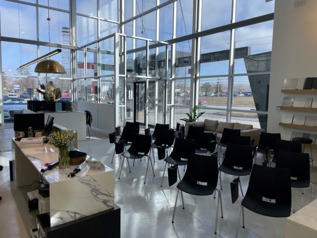 Sunlit showroom prepared for the Cosentino event Stone Design Concepts, with rows of chairs and a spacious glass entryway offering views outside.