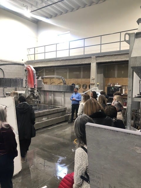 Attendees touring the workshop at the Cosentino event Stone Design Concepts, learning about stone fabrication processes and machinery used in production.