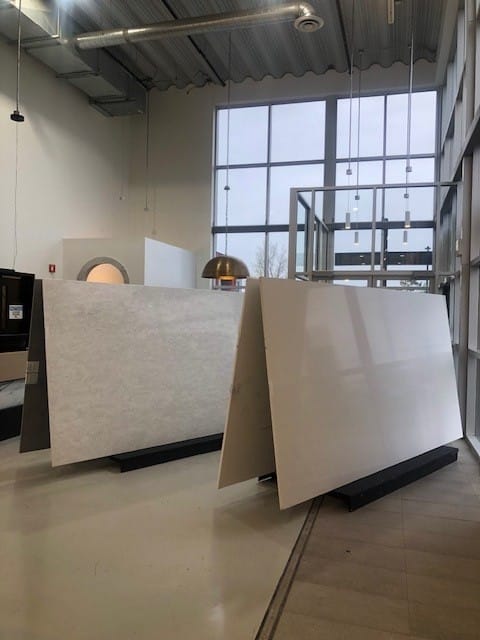 Large stone slabs displayed at the Hanstone colour launch event, showcasing various textures and finishes in a well-lit, industrial-style showroom.